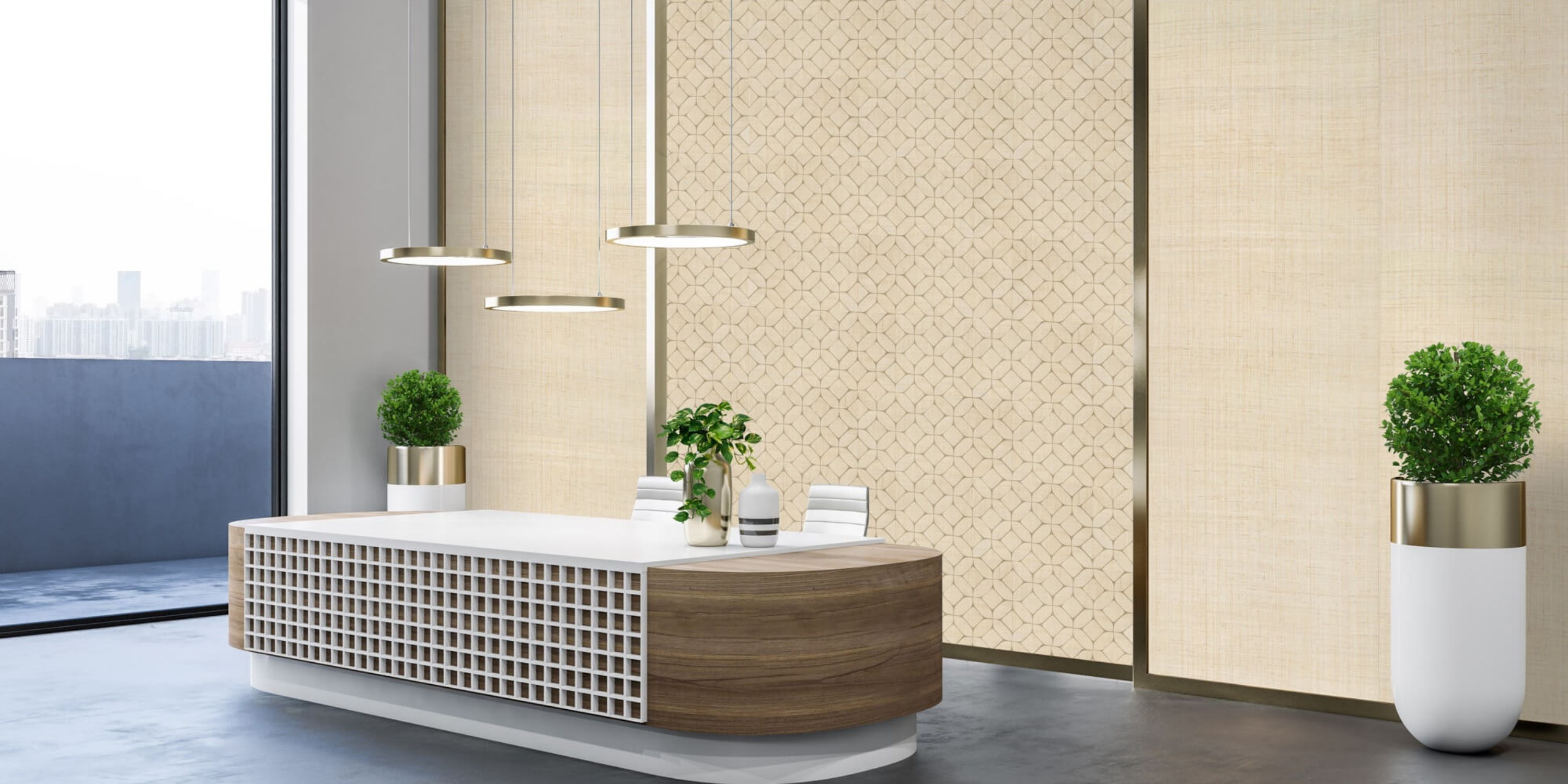 Modern office reception with a wooden and white lattice desk, two potted plants, and three sleek hanging lights. Beige patterned walls create a calm, welcoming atmosphere.