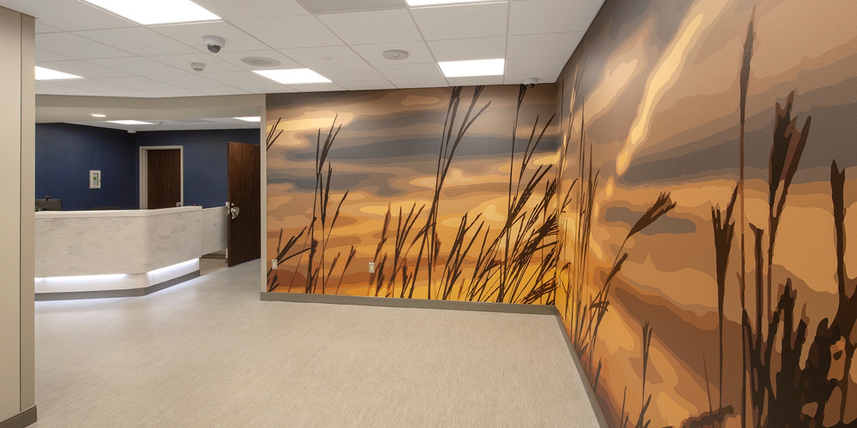 A hallway featuring a vibrant mural depicting various grasses along the walls.