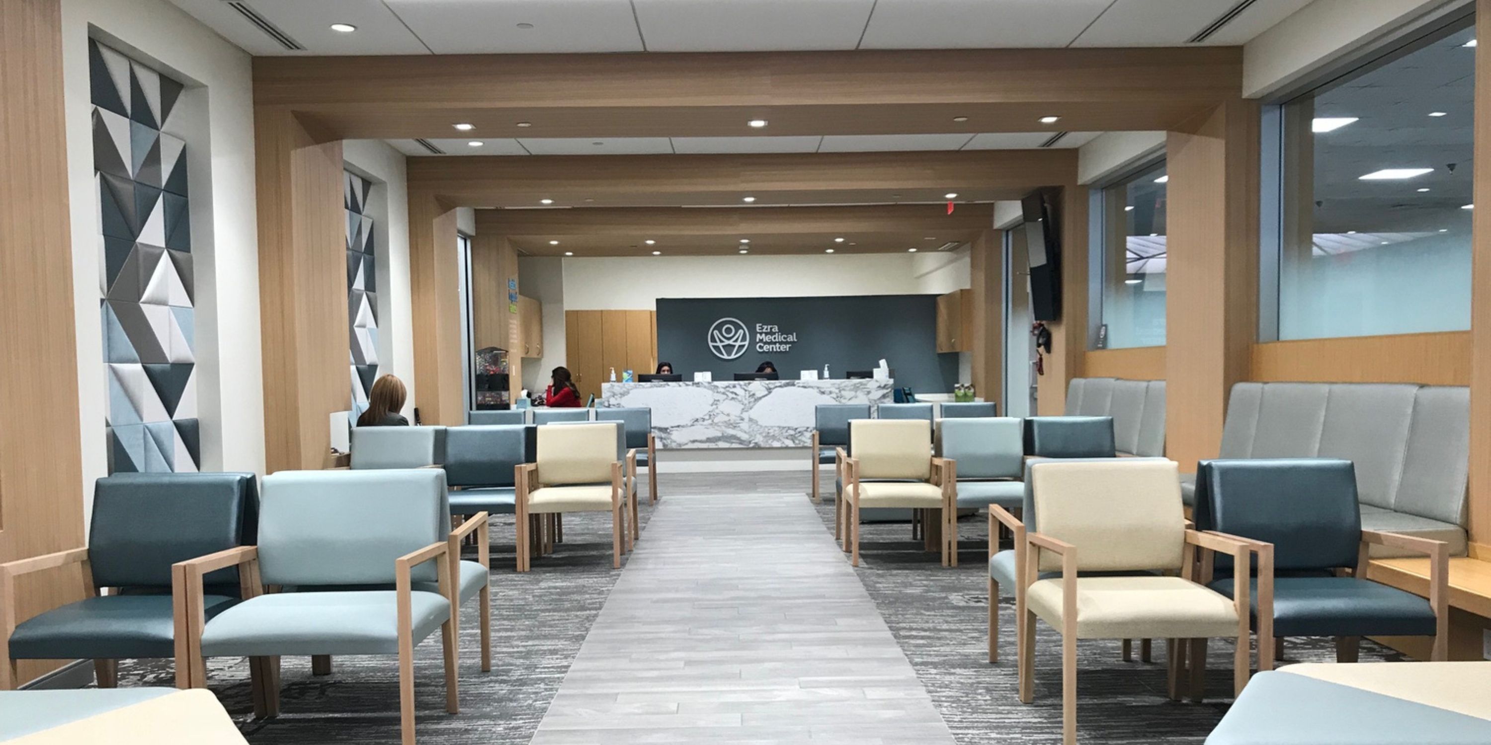 A long hallway featuring several chairs and tables arranged along the sides.