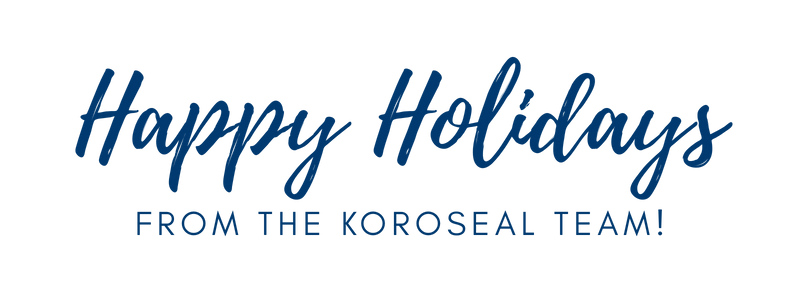 Blue script text on black background reads, "Happy Holidays from the Koroseal Team!" The tone is festive and warm.