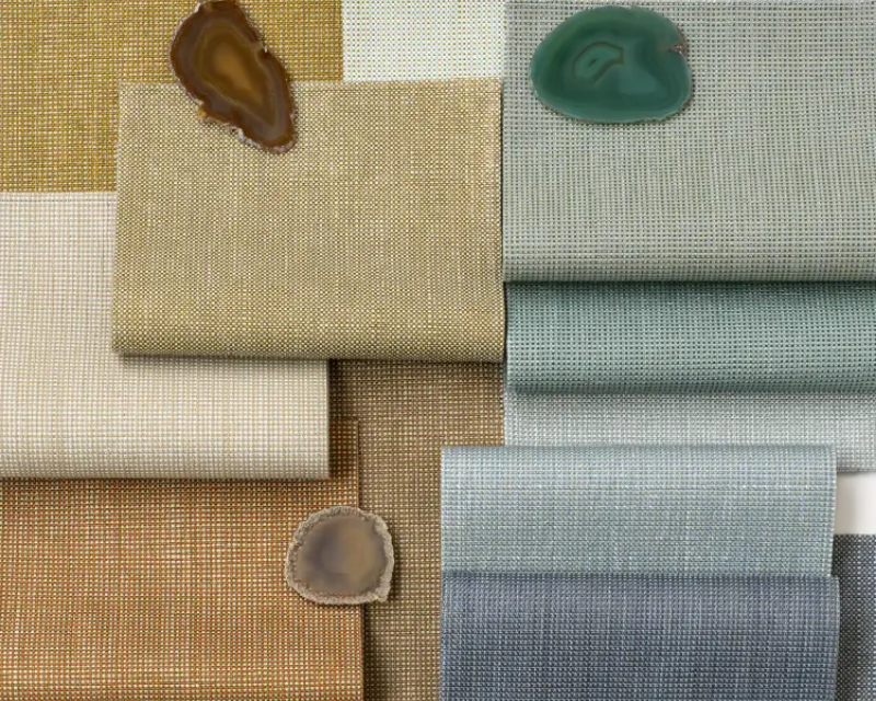 Folded fabric samples in beige, gold, and blue tones are arranged with three polished agate stones, creating a calm and elegant composition.