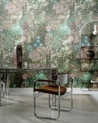 Office with a glass desk, metal-framed chair, arched shelf, and green floral-patterned wallpaper.