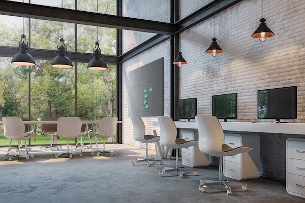 Modern office with large windows, natural light, white brick walls, and industrial lamps. Includes a computer desk and a meeting table, evoking a minimalist and open atmosphere.