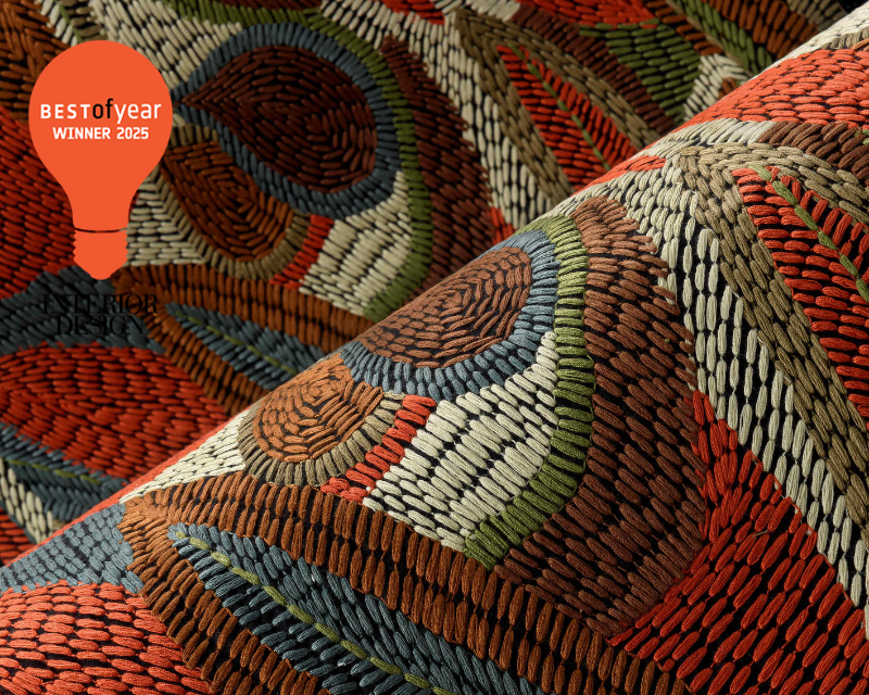 The image showcases a vibrant textile pattern with woven multicolored threads in earth tones. A "Best of Year Winner 2025" badge is in the top corner.