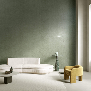 Modern living room with a minimalist design. Features a curved white sofa, yellow armchair, round tables, and a green textured wall, creating a calm ambiance.