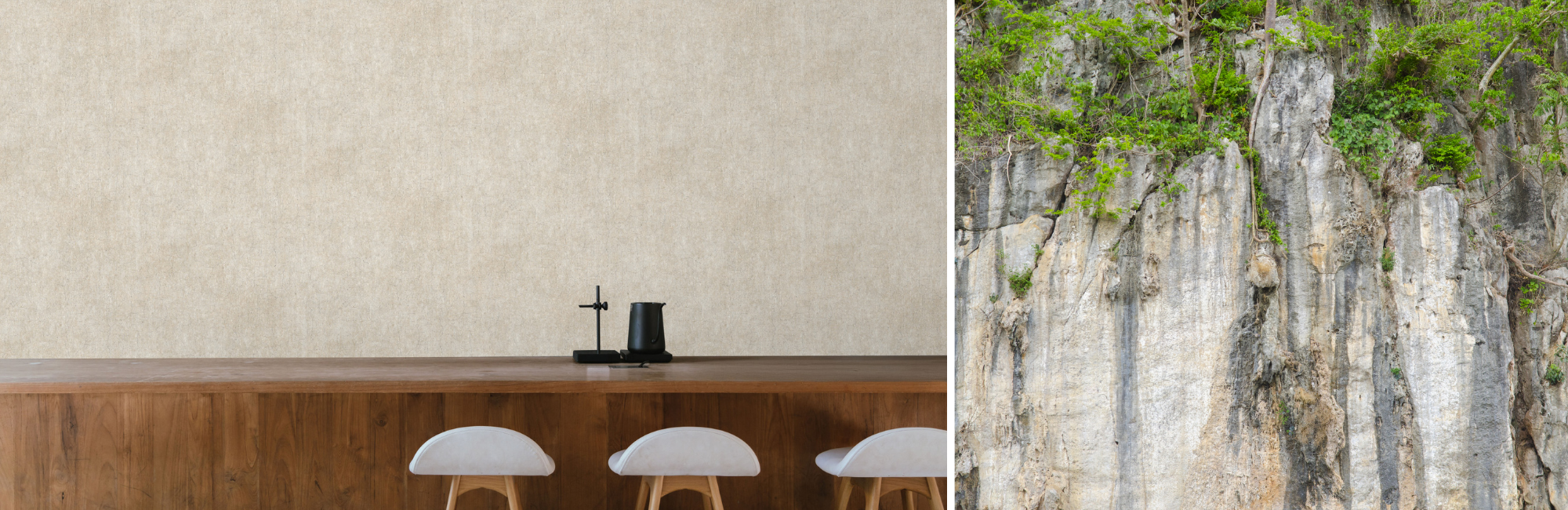 A minimalist interior features a wooden table with three white chairs and a black vase, next to a natural rock wall covered in green foliage.