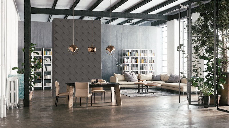 Spacious industrial-style loft with gray walls, large windows, and exposed beams. Features modern furniture, bookshelves, plants, and pendant lights.