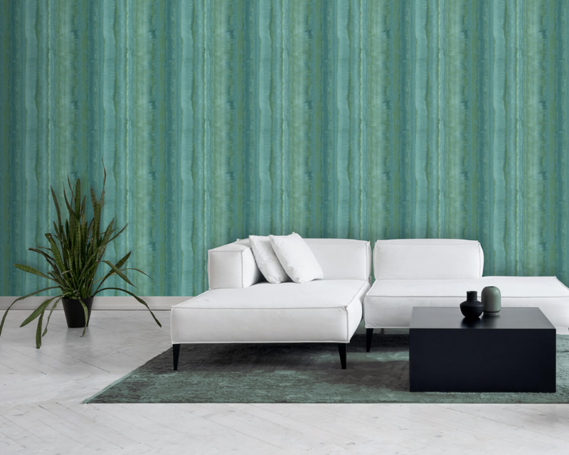 Modern living room with a white sectional sofa, black coffee table, and potted plant against a teal-striped wallpaper. Calm and stylish ambiance.