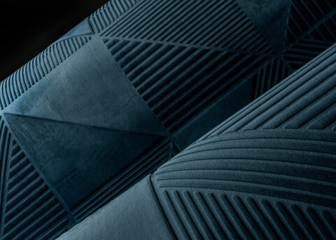 Close-up of a textured blue fabric with geometric patterns, including triangles and stripes, creating a modern and sophisticated look.