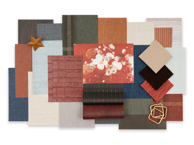 A collage of wallcovering samples in various textures and colors, including reds, blues, and neutrals, arranged with a wooden star and gold wire shapes.
