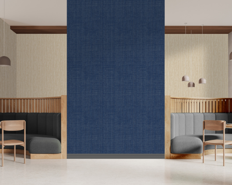 Modern cafe interior with two cozy booths separated by a textured navy wall. The booths have wooden frames, gray cushions, and pendant lights above. Calm ambiance.